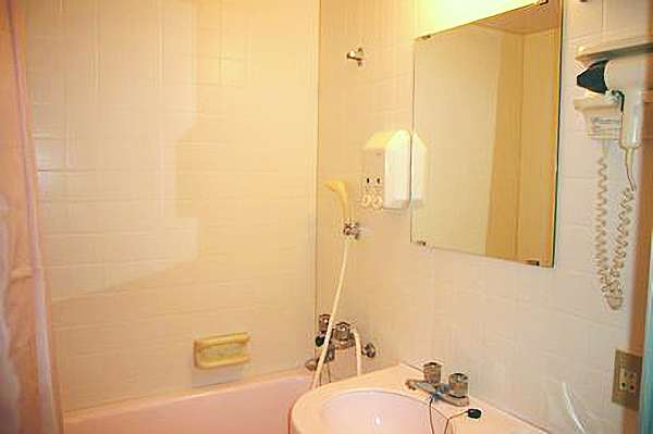 浴槽上部にシャワーが付いており、鏡付きの洗面台もあるバスルームのイメージ